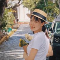 Yuxin Jia standing in a street holding flowers